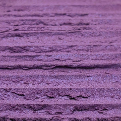 Close-up of fingers applying shimmery purple and blue duochrome loose powder eyeshadow to eyelid