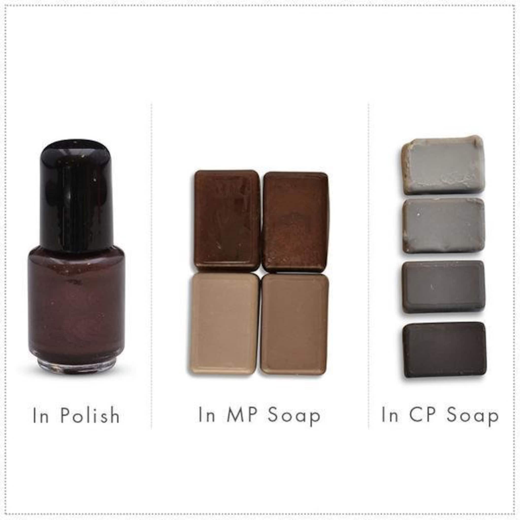 Nail polish bottle with brown liquid, black cap, and clear glass, next to soap samples