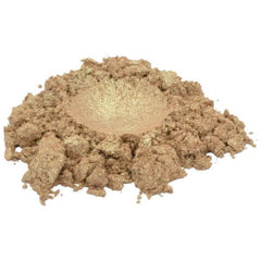 Golden cinnamon sugar mica pigment powder spilled artistically on marble surface with brush