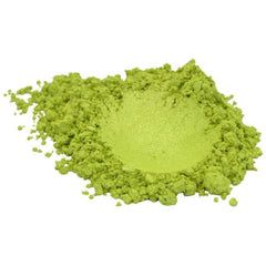 Vibrant green apple mica pigment powder spilled on marble surface with shimmer particles catching light