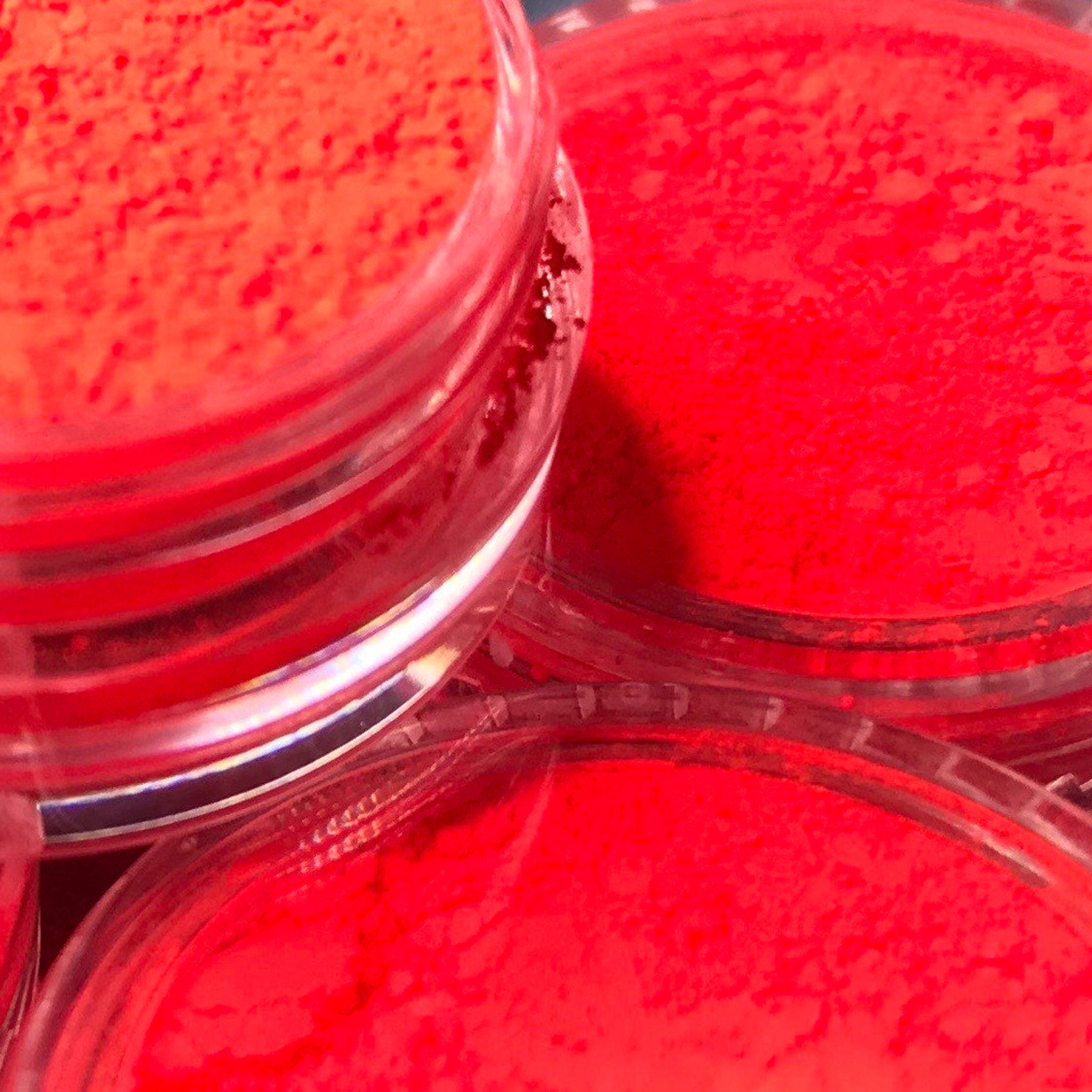 Side view of vibrant red eyeshadow pigment pot showing rich matte texture and compact size