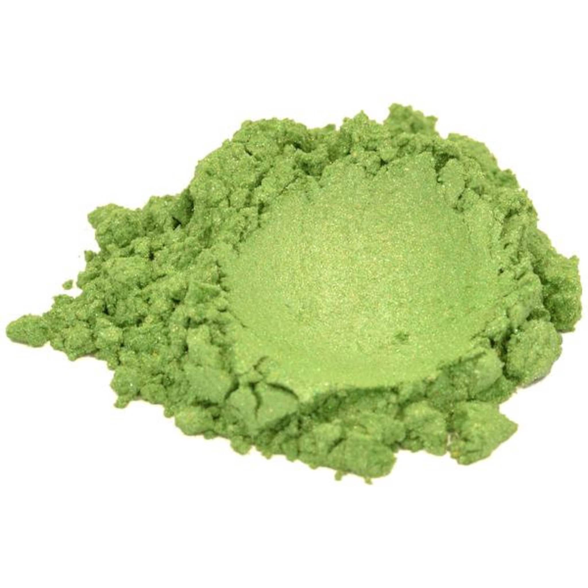 Side view of vibrant green mica powder in a clear plastic jar showing fine shimmer particles