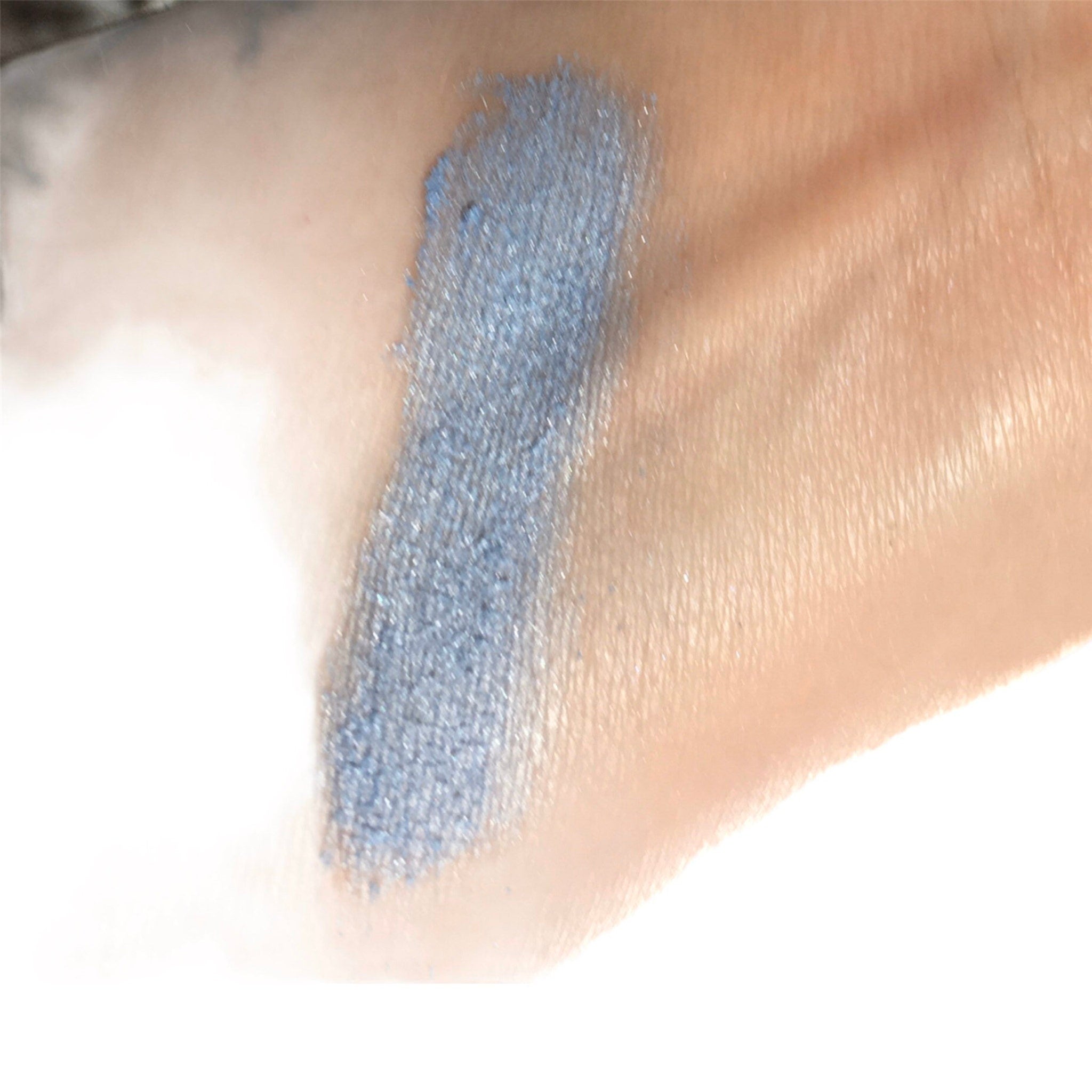 Eyeshadow swatch in blue with shimmer on skin, for color comparison