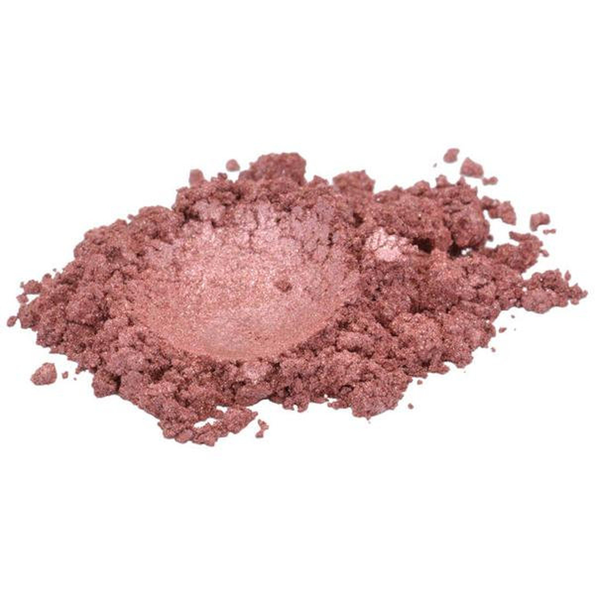 Close-up of rich Tibetan ochre red-brown mica powder spilling from a cosmetic jar onto a textured surface