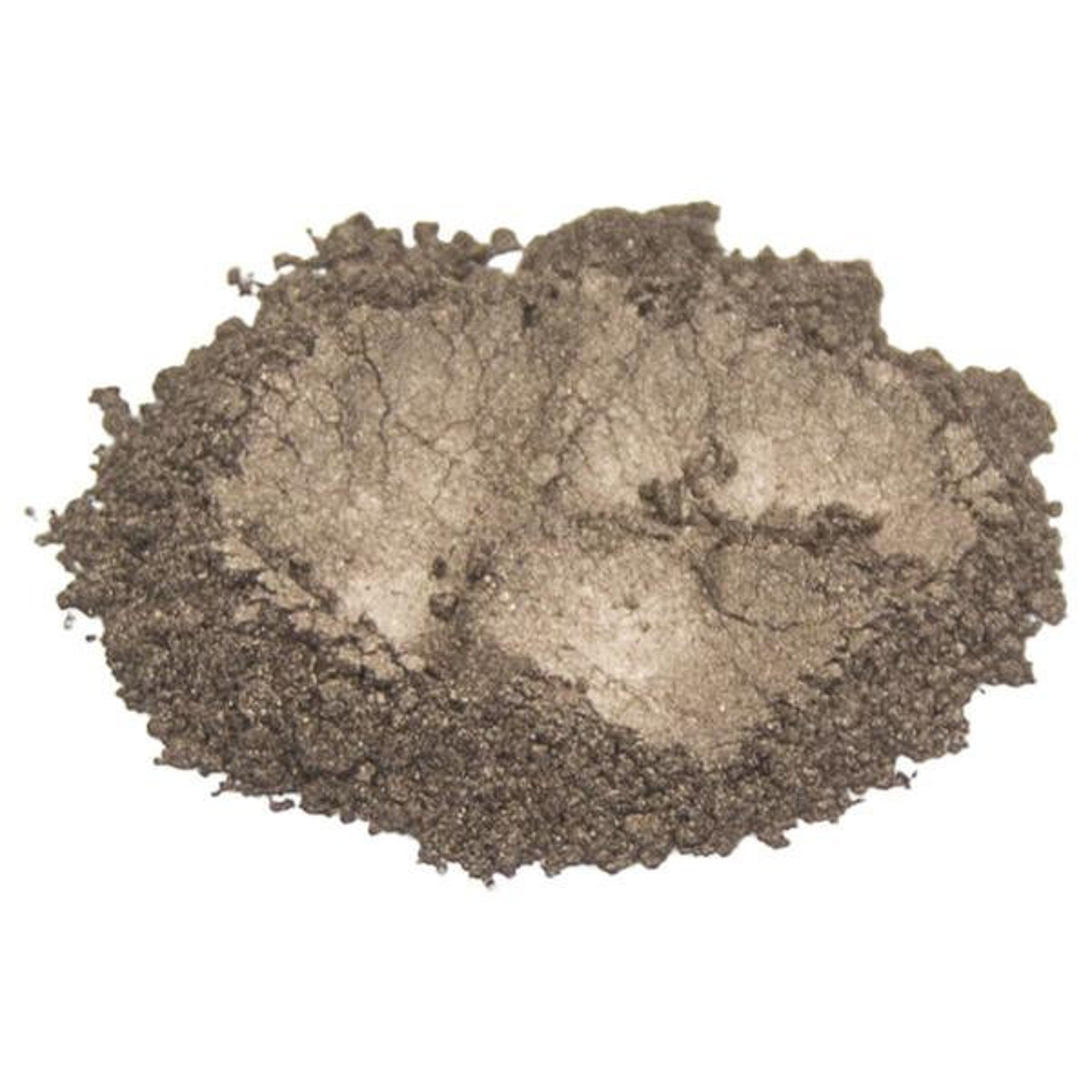 Hand applying warm wood brown mica pigment powder eyeshadow with a fluffy brush onto eyelid.
