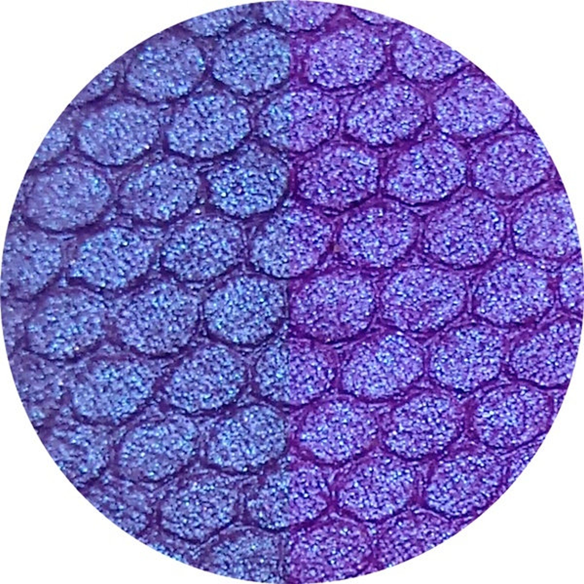Close-up swatch of duochrome blurple eyeshadow shifting from blue to purple in natural light