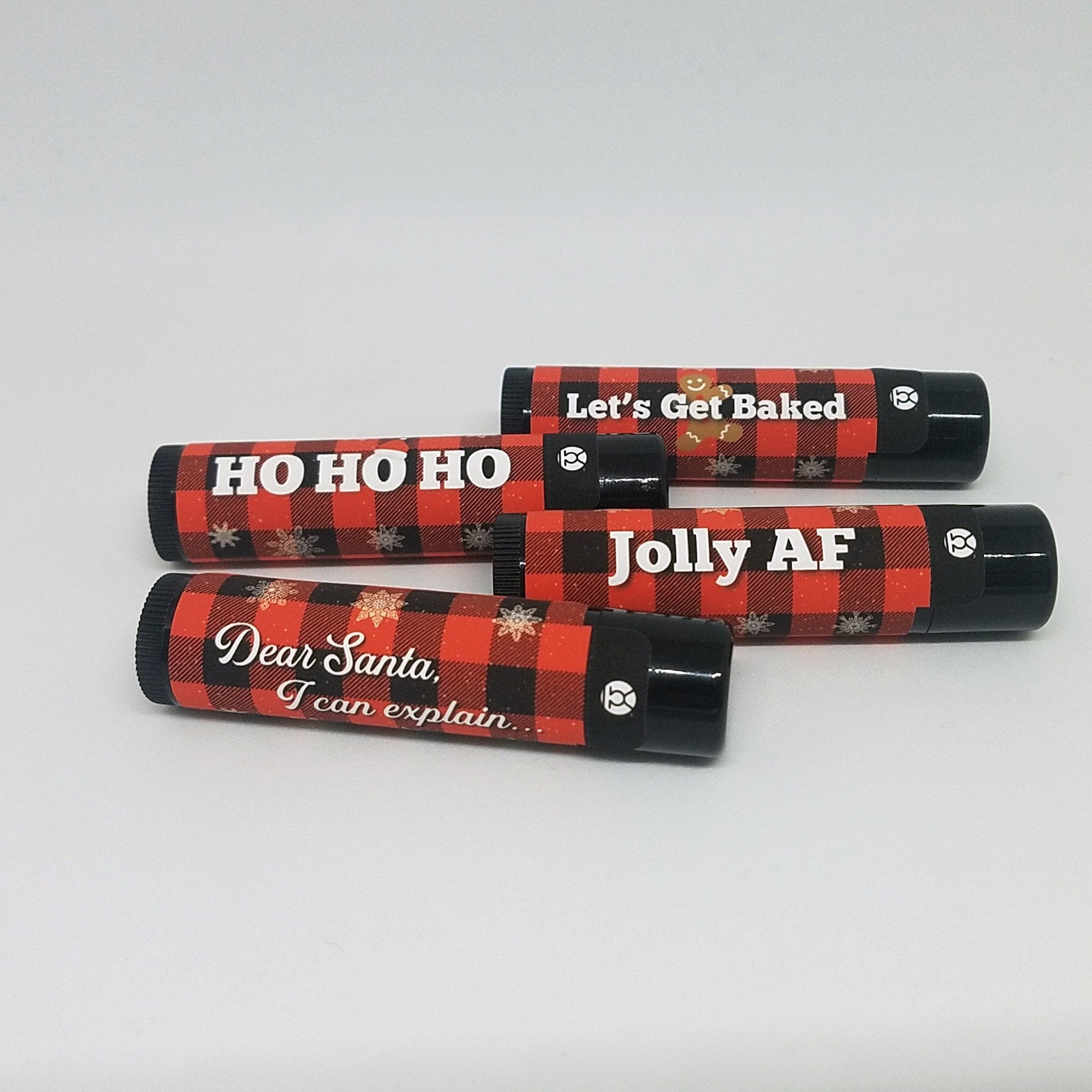 Lip balm tubes with red and black plaid pattern, text, and black caps, for Christmas