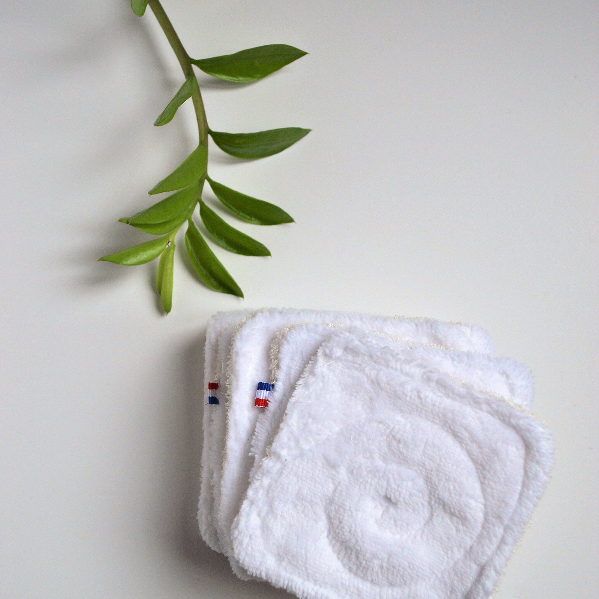 Close-up of double-sided bamboo makeup wipe showing textured weave and OEKO-TEX certification seal