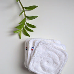 Close-up of double-sided bamboo makeup wipe showing textured weave and OEKO-TEX certification seal