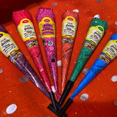 Close-up of vibrant vegan henna paste cones in purple, red, magenta, orange, green, and blue with smooth texture
