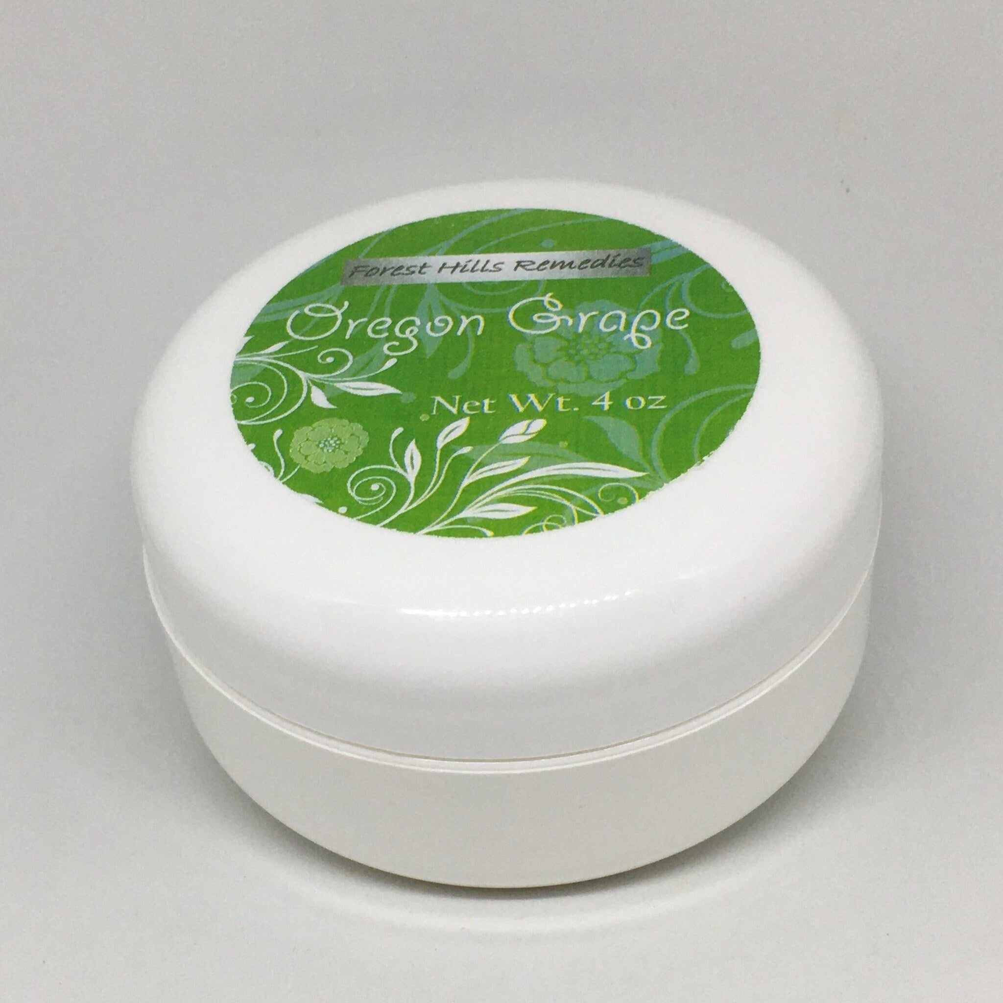 Close-up of creamy Oregon Grape moisturizer with golden mahonia extract in a minimalist white jar