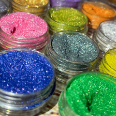Twelve vibrant shimmery vegan eyeshadows in a sleek palette with mirrored lid and gradient hues.