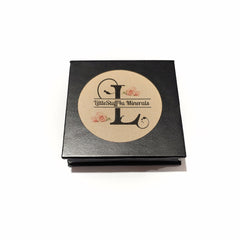Side view of platinum silver mineral eye shadow compact showing reflective metallic finish and smooth texture