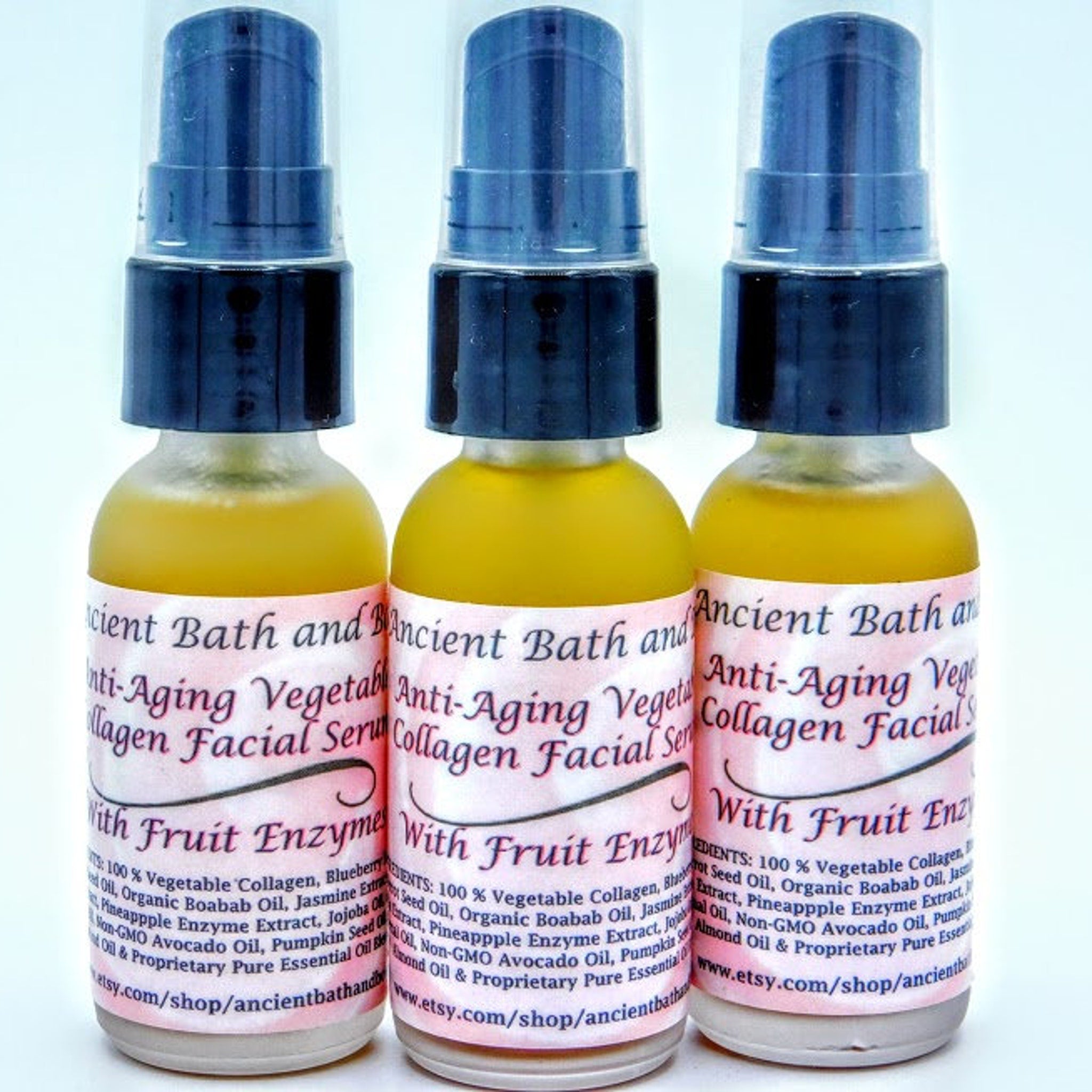Facial serum bottles with blue pump, yellow liquid, and pink label displaying "Ancient Bath" text