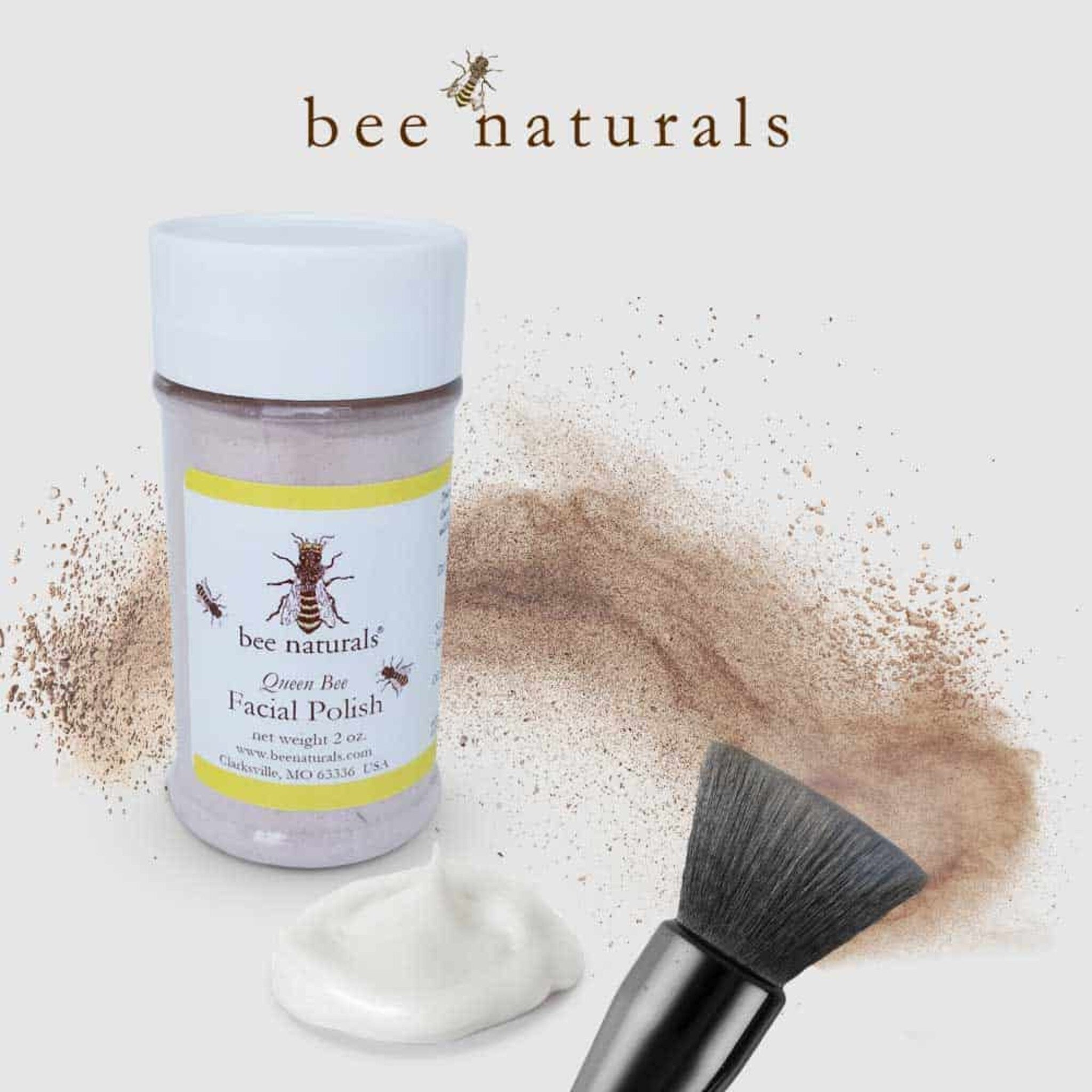 Facial polish jar with white lid, yellow label, and "bee naturals" text, with brush and powder