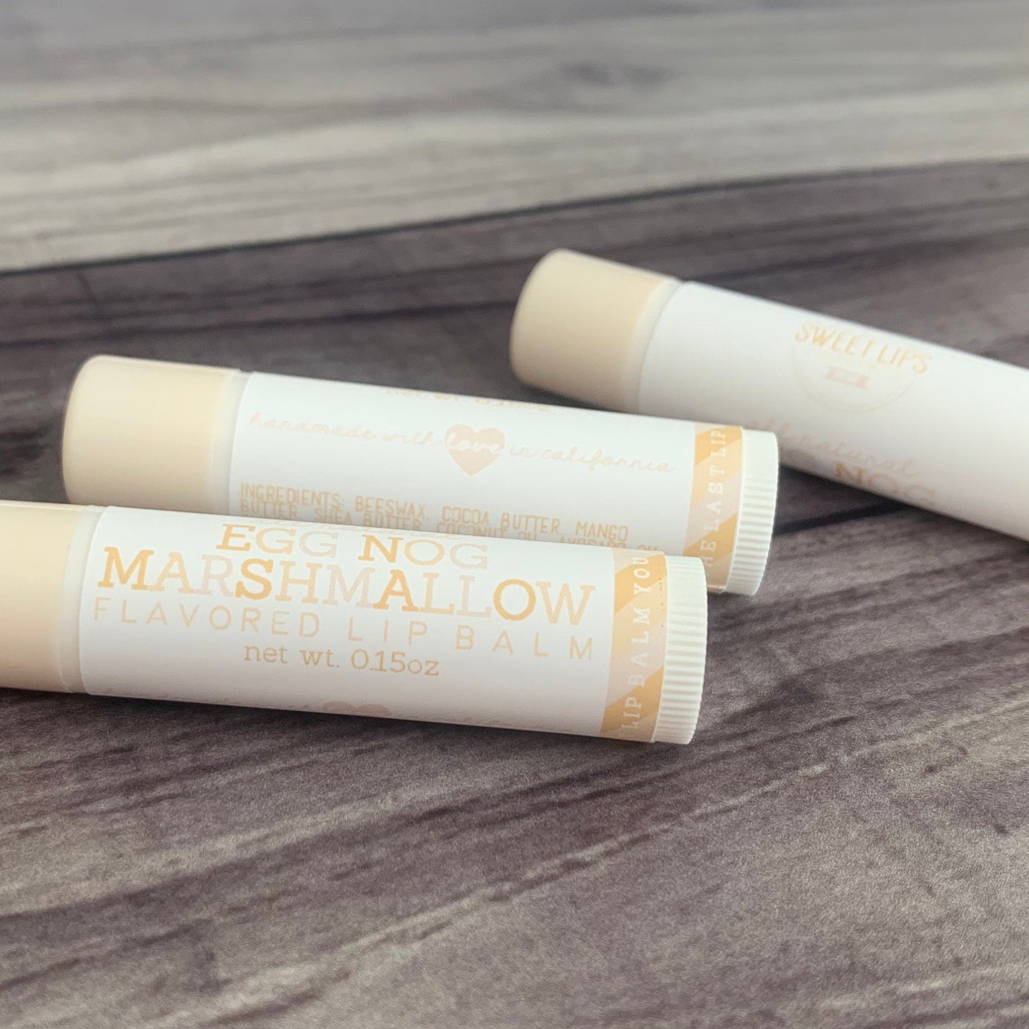 Lip balm tubes with white and beige packaging, Egg Nog Marshmallow flavor, Sweet Lips brand