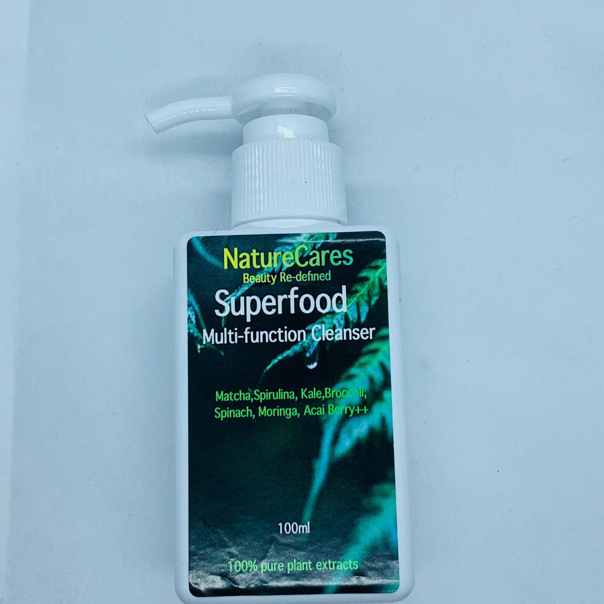 Multi-function cleanser bottle with white pump, green label, and "NatureCares Superfood" text