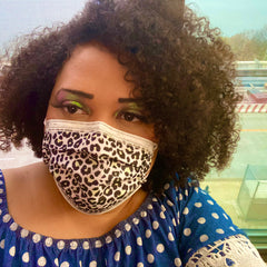 Face mask with leopard print, white, black, and disposable material, worn by a person