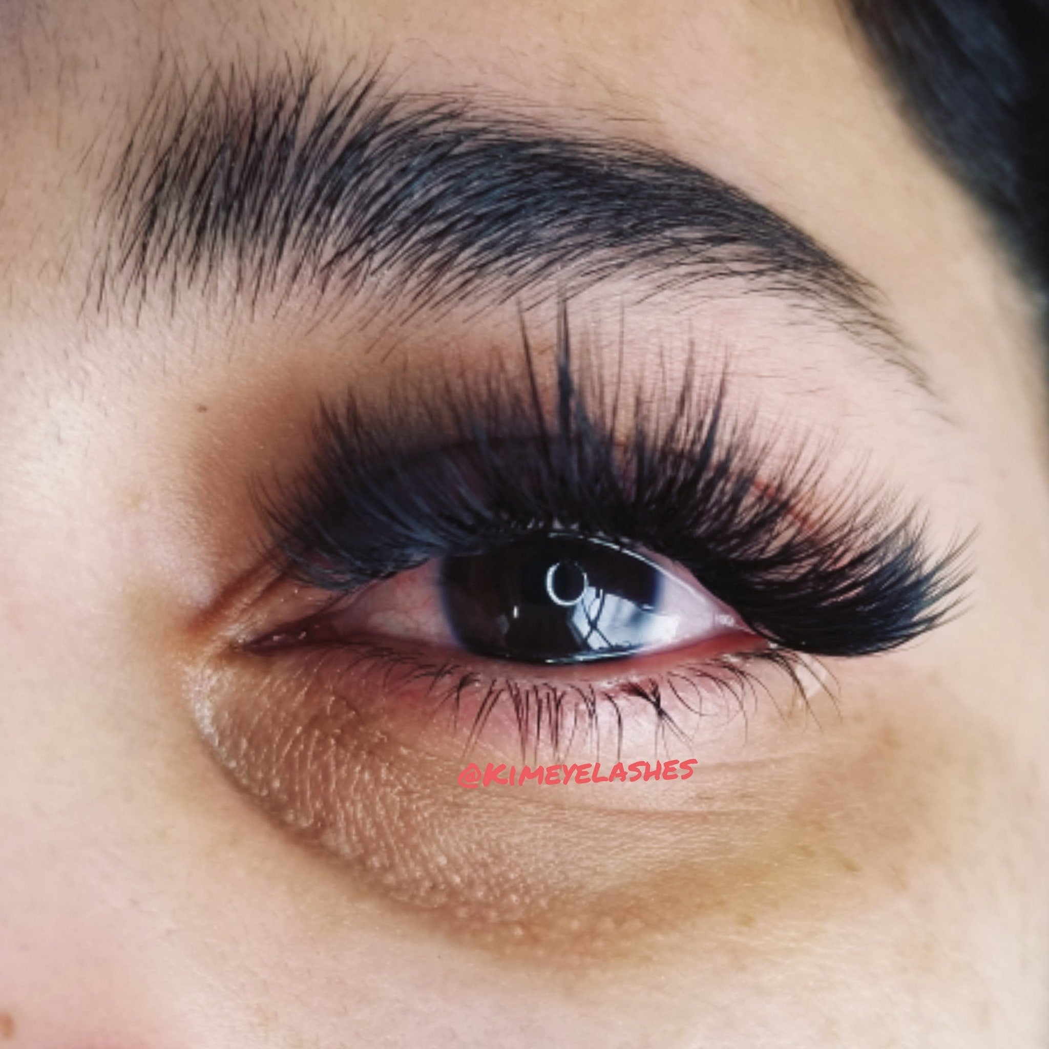 Eyelashes, black, long, dramatic style, with @KIMEYELASHES text visible on skin