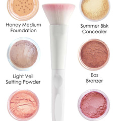 Makeup brush with white handle, pink and white bristles, and various makeup colors around it