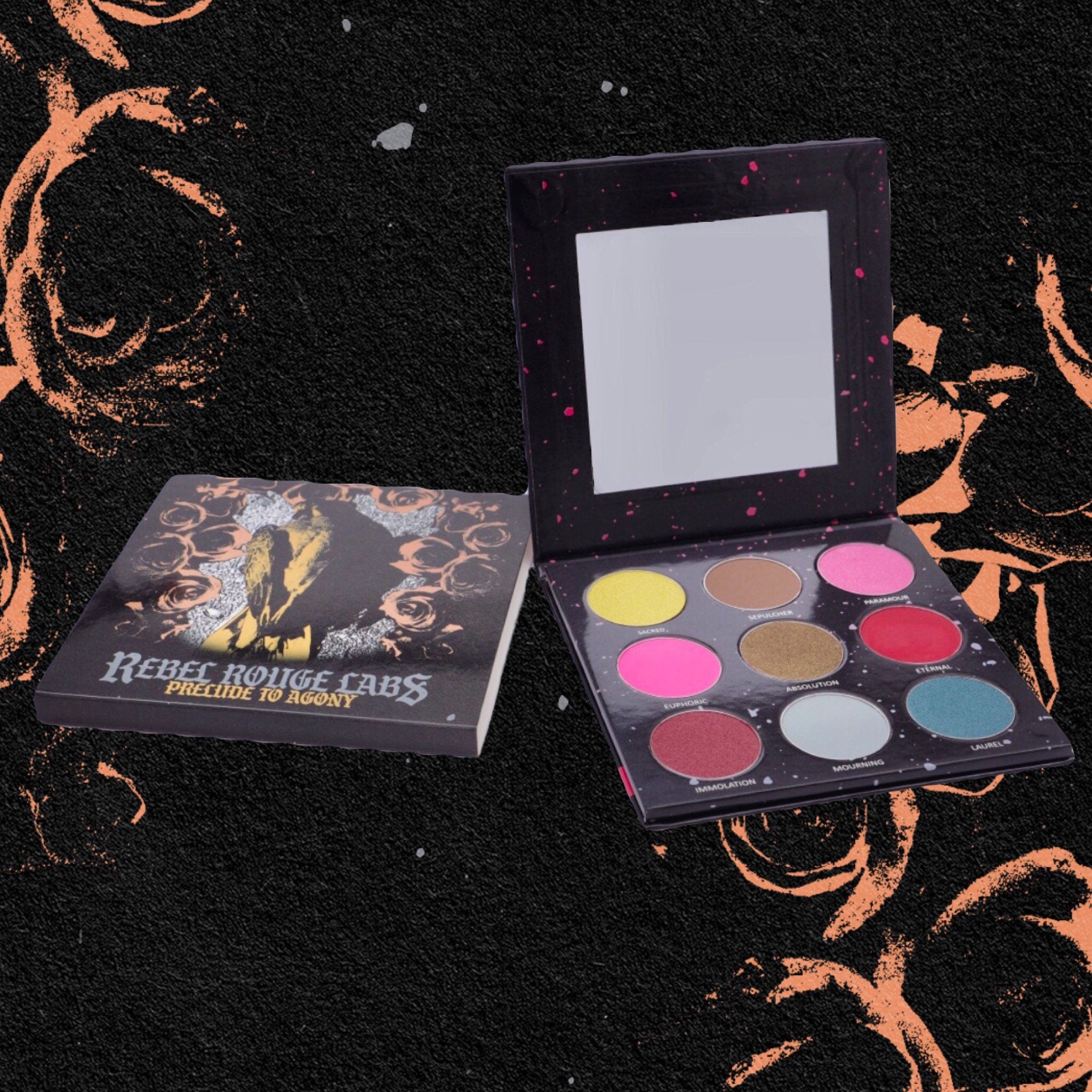 Side view of Divine Tragedy eyeshadow palette showing gothic dark red and black matte shades with embossed logo