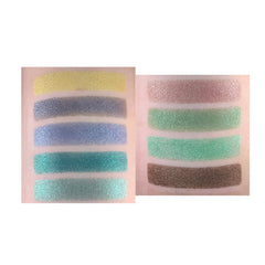 Hand applying shimmery forest green eyeshadow from palette with a fluffy brush