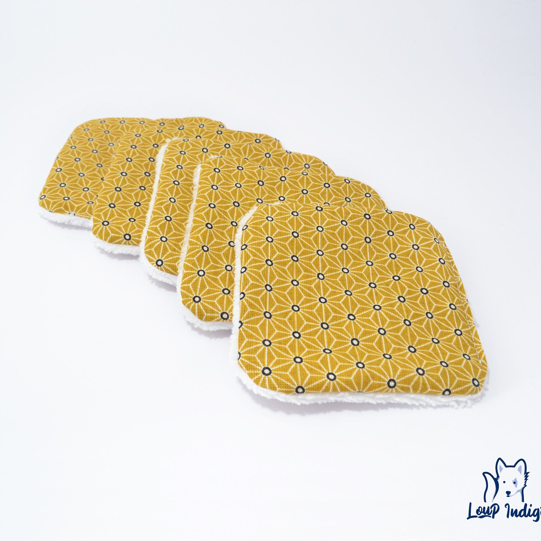 Reusable wipes with yellow geometric pattern and white fluffy trim, Loup Indigo logo visible