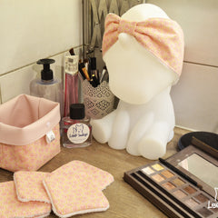 Headband with pink and yellow geometric pattern, white trim, worn on a unicorn lamp