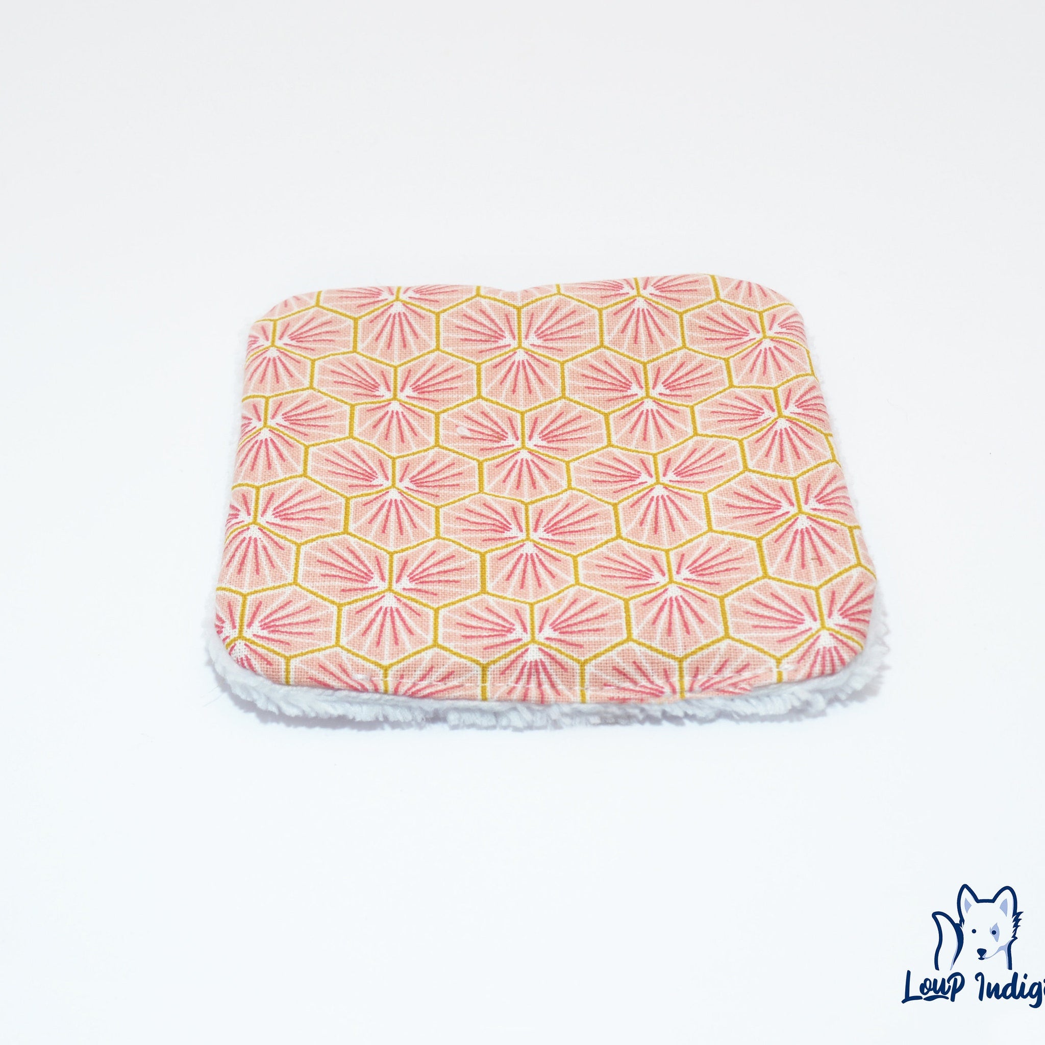 Reusable face cloth with pink geometric pattern, white trim, and Loup Indigo logo