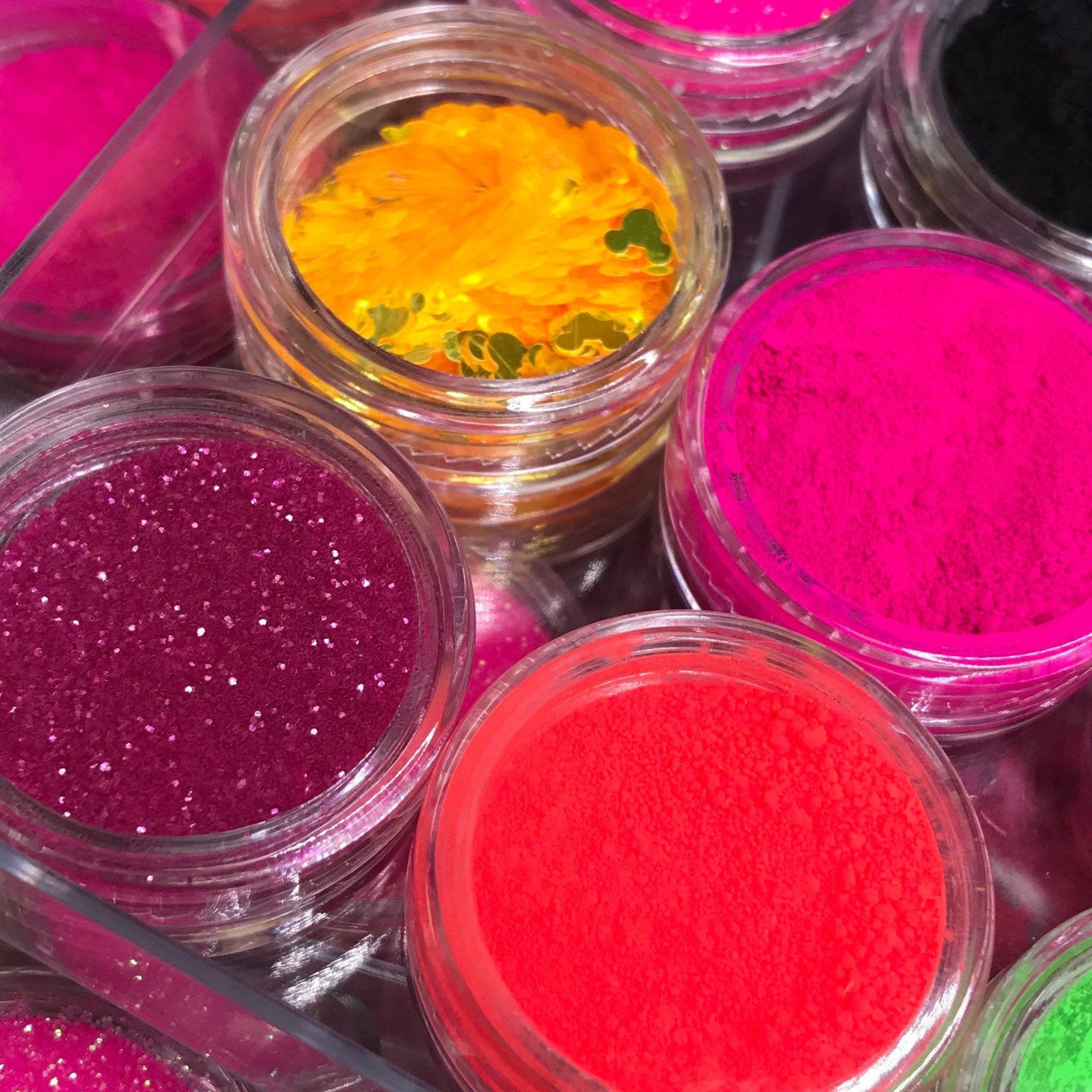 Open vegan neon eyeshadow palette showing six vibrant matte shades in bright pink, orange, yellow, green, blue, and purple