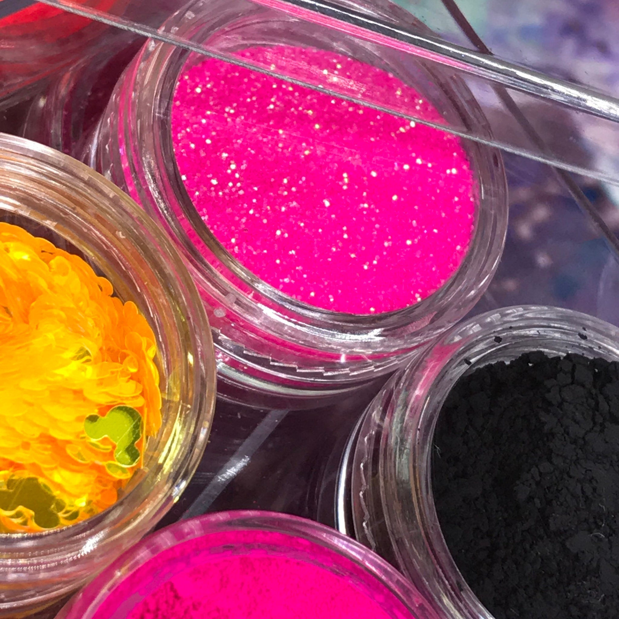 Side view of vegan neon eyeshadow palette showing vibrant matte pans in electric pink, lime, and cobalt blue