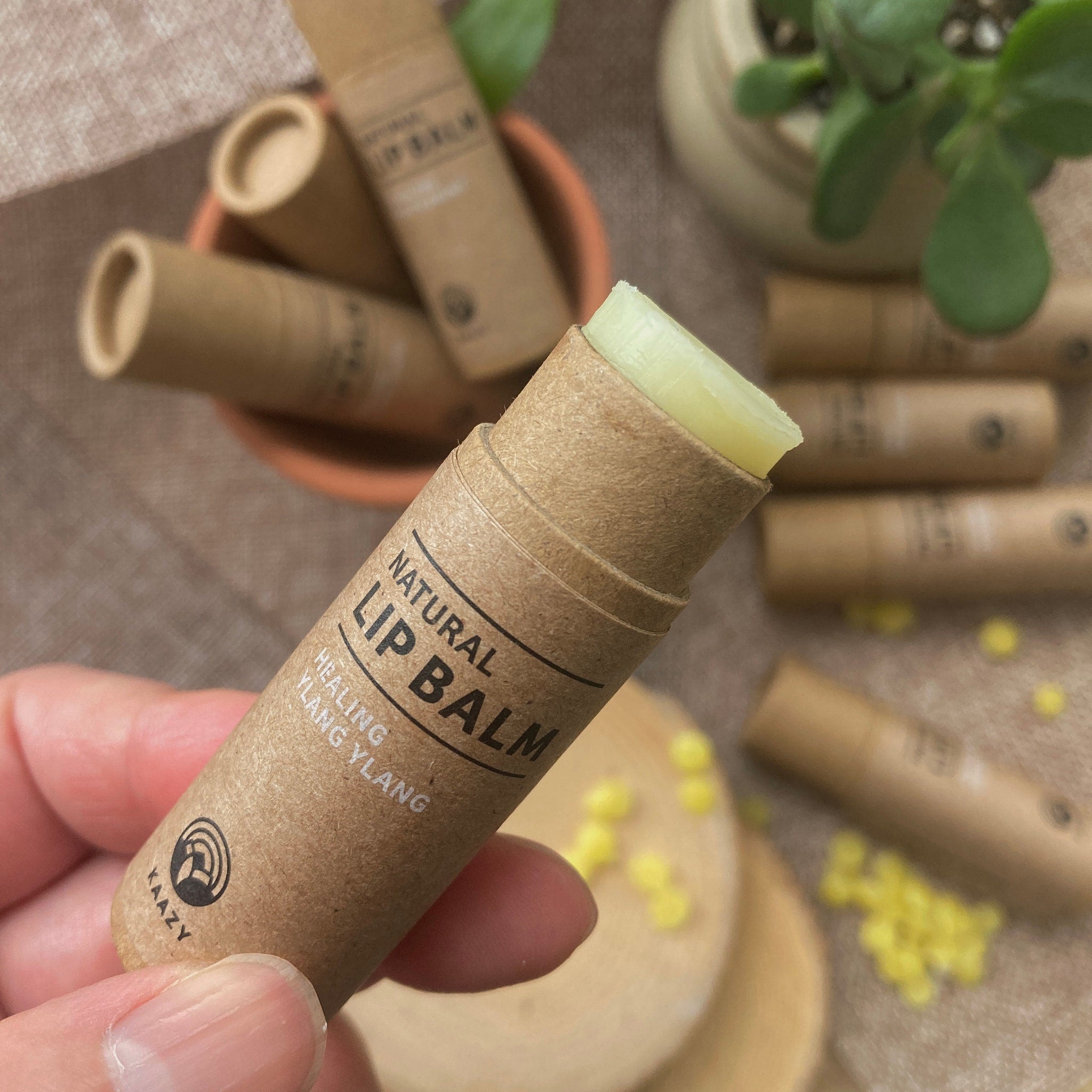 Lip balm in brown paper tube with visible green balm and "Kaazy" brand text