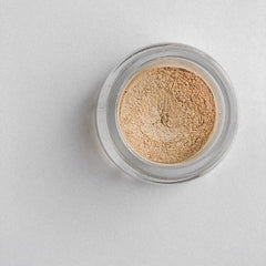 Side view of champagne gold shimmer eyeshadow pot showing metallic finish and compact size