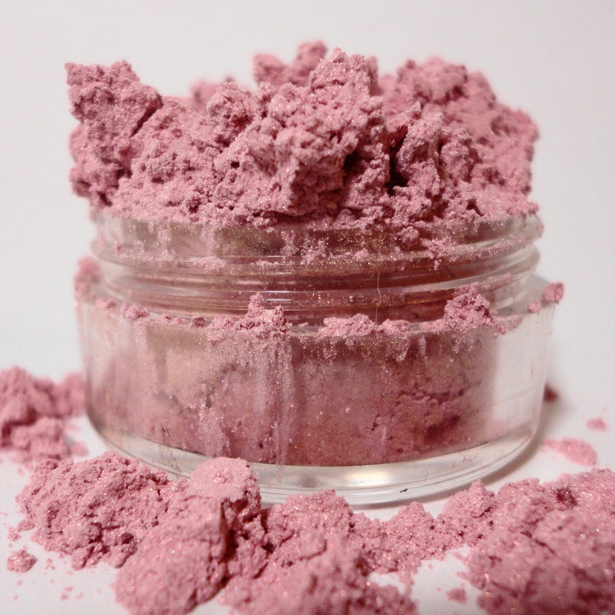 Side-angle view of pale pink shimmer mineral eyeshadow in compact with luster finish and vegan label