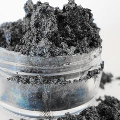 Black eyeshadow powder with glitter in a clear plastic container