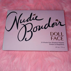 Side view of Dollface Nudie Boudoir palette showing 12 matte and shimmer nude eye shadows in rectangular pans with gold trim