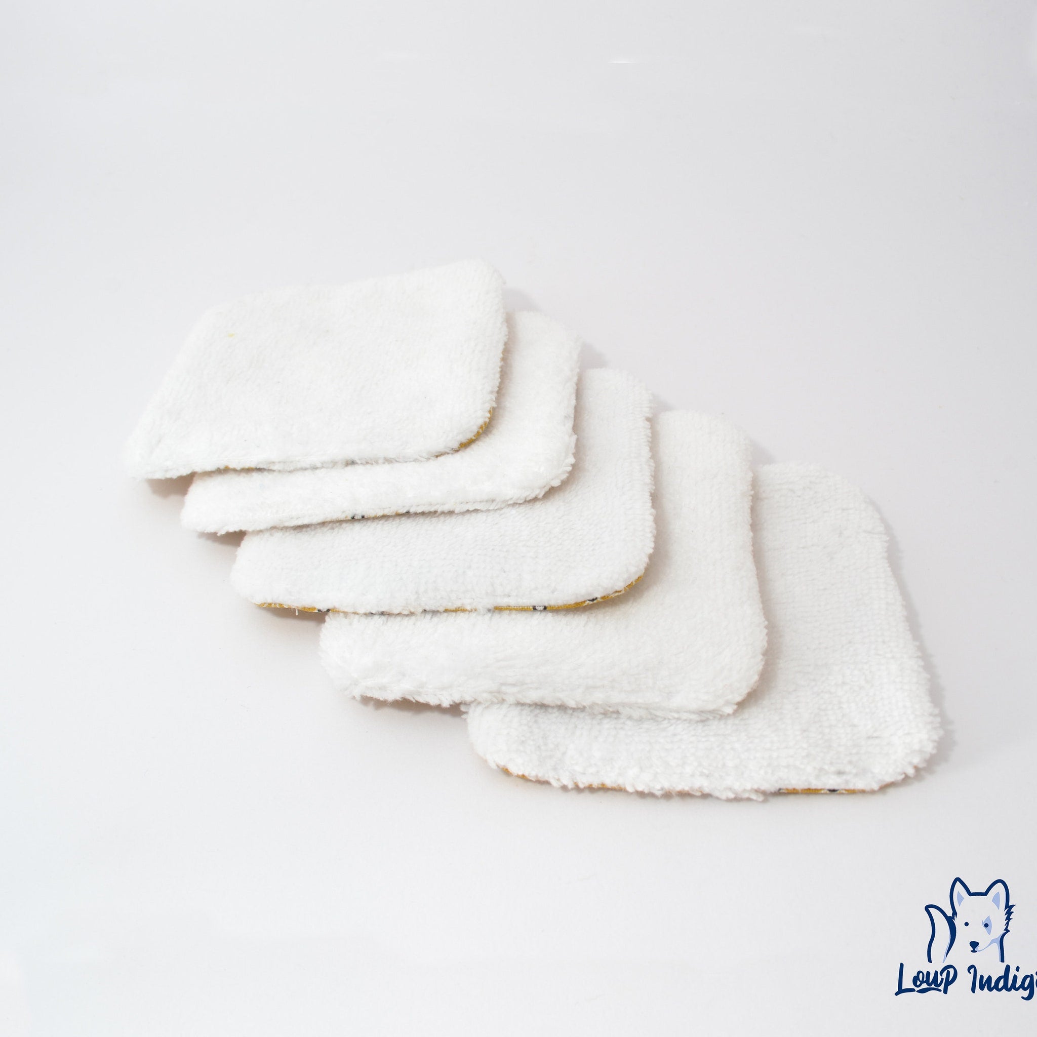 White microfiber face cloths with yellow trim, Loup Indigie logo visible