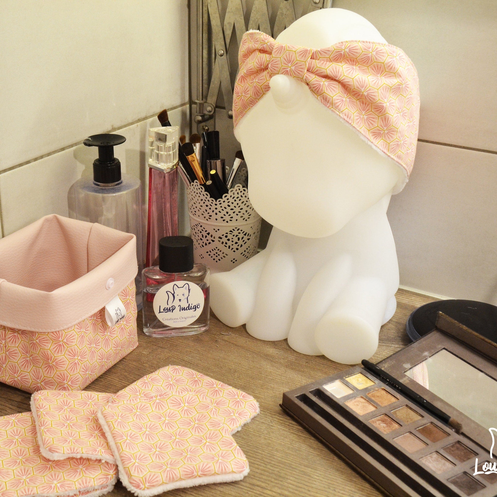 Headband with pink and yellow geometric pattern, white trim, worn by unicorn statue