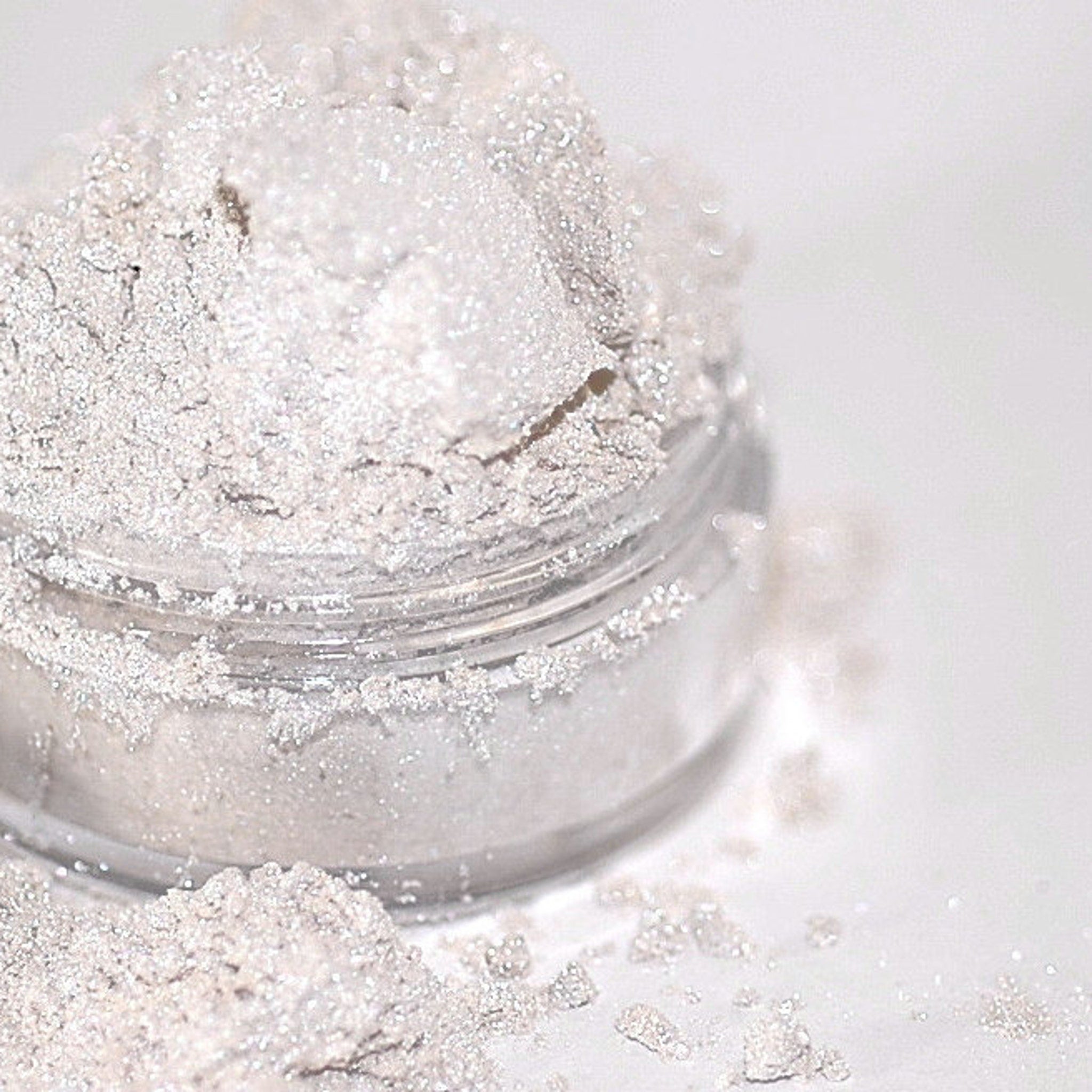 Close-up of iridescent white and pink mineral eye shadow duo with sparkling shimmer particles