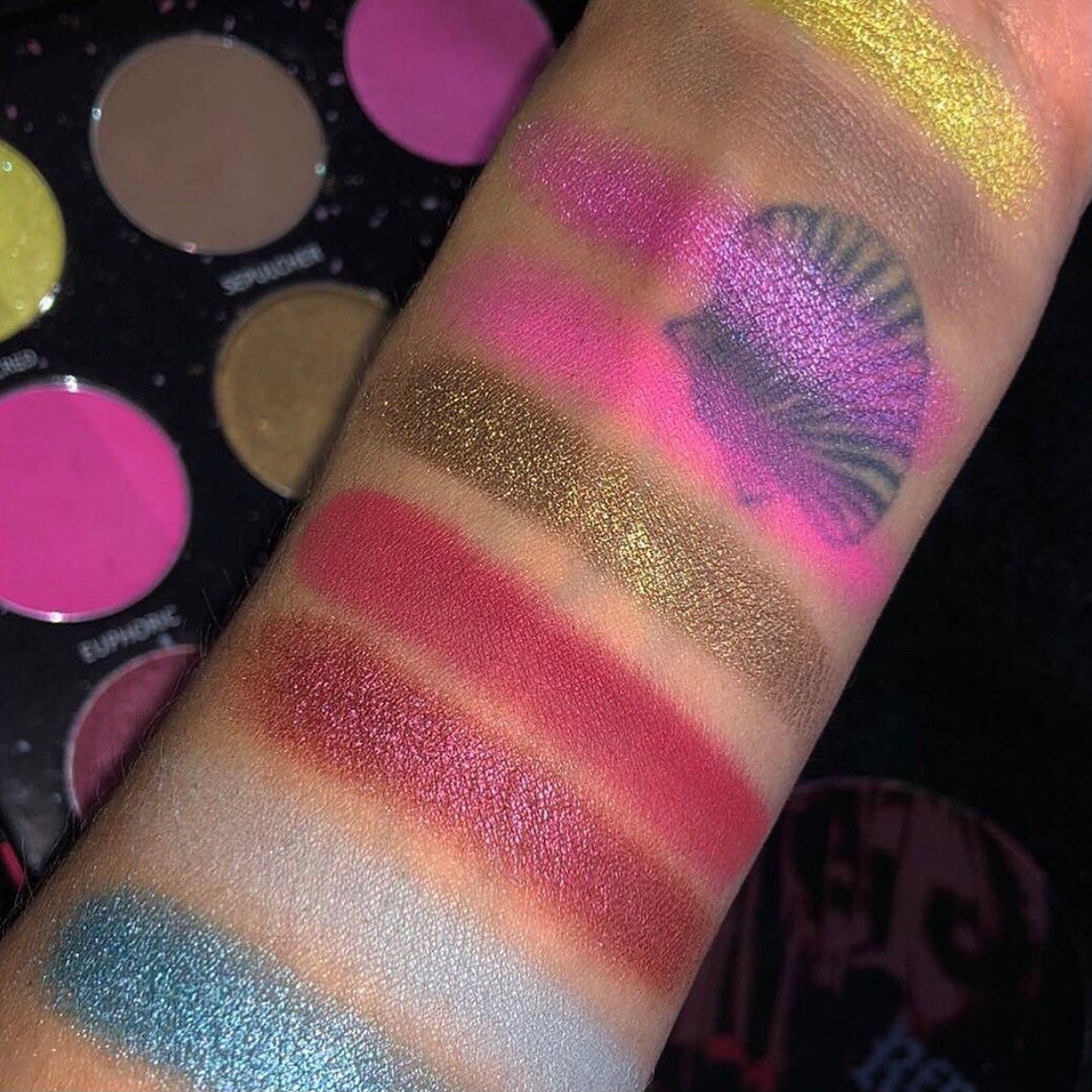 Side view of Divine Tragedy eyeshadow palette showing gothic shades in matte and shimmer finishes with ornate packaging