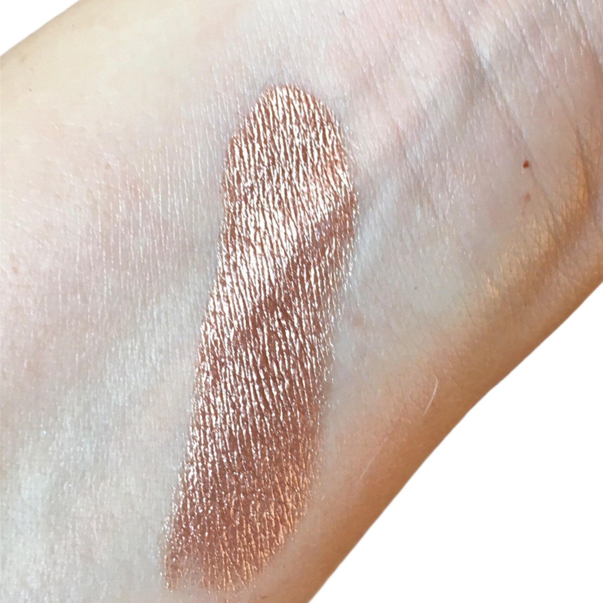 Swatched eyeshadow, metallic bronze color with textured finish on skin