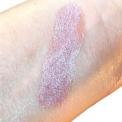Swatched lip gloss in pink with shimmer applied to skin.