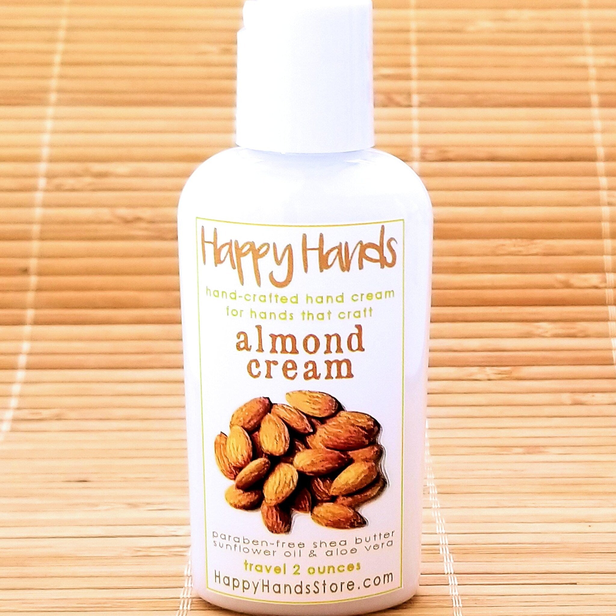 Close-up of smooth almond cream shea butter hand cream in a minimalist white tube with gold accents, texture visible