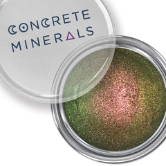 Eyeshadow with multichrome green and pink shimmer, in a silver container, Concrete Minerals brand visible