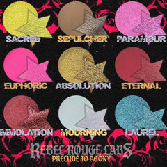Close-up of Divine Tragedy eyeshadow palette showing deep burgundy and matte black shades with gothic detailing