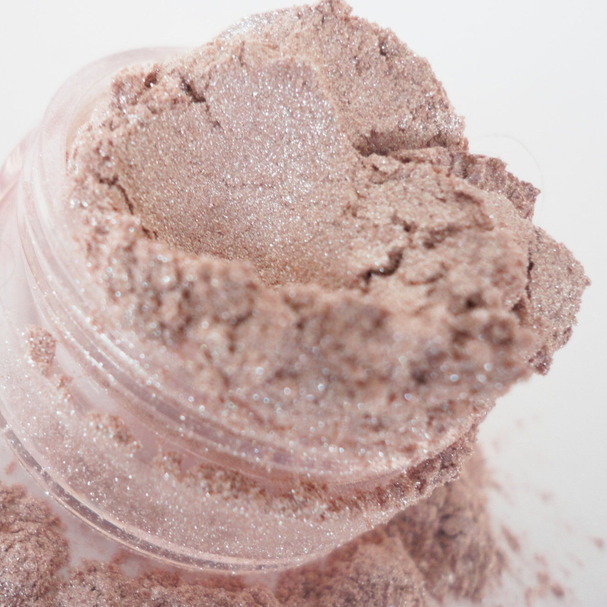 Open 10g jar of Bombshell Peach eyeshadow with shimmer and glitter, showcasing peachy-gold pigment texture