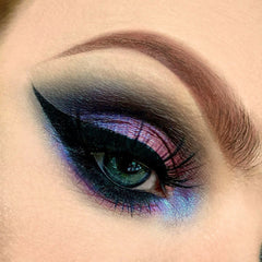 Close-up of matte black mineral eyeshadow pan with smooth, pigmented powder texture and vegan logo