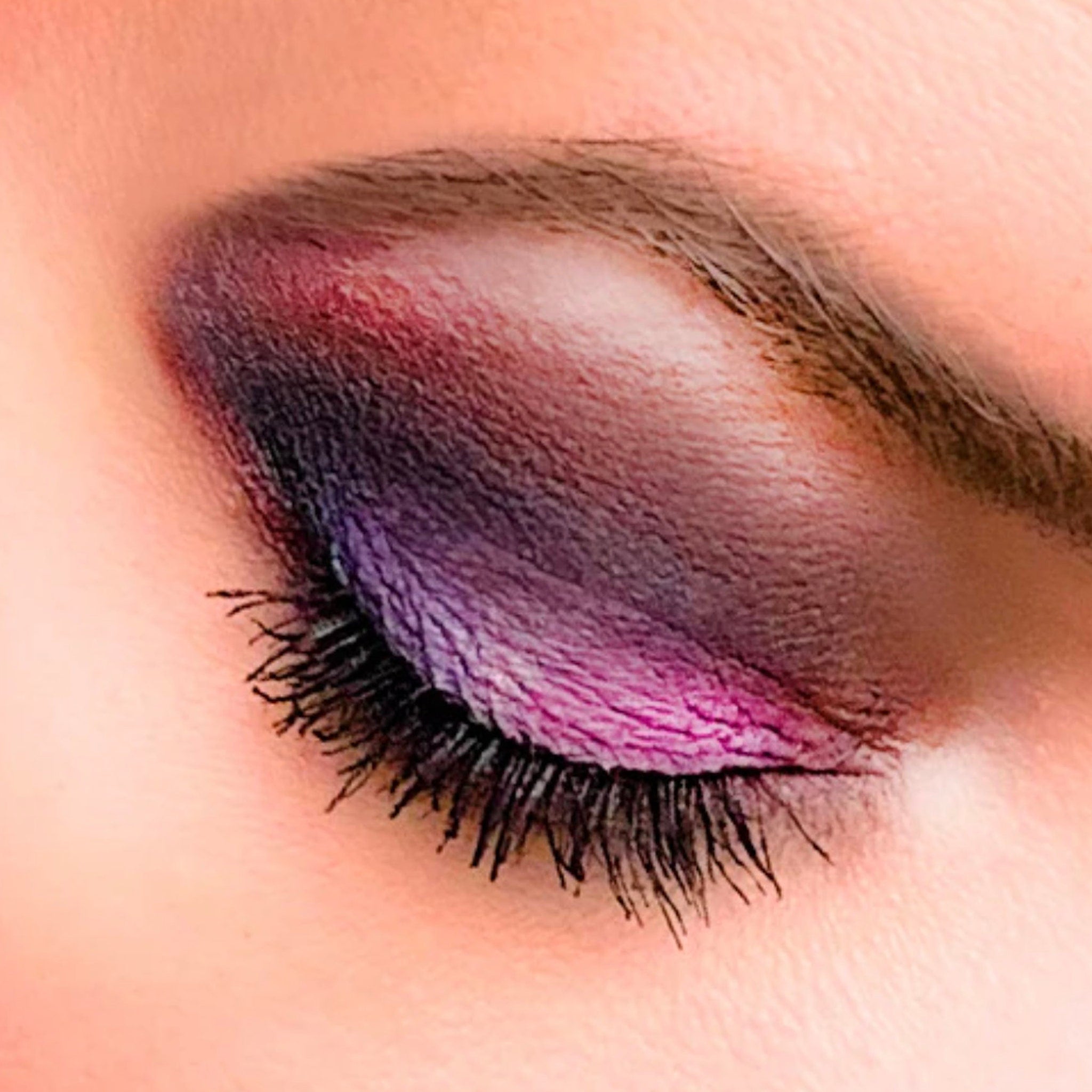 Side view of black mineral eyeshadow pot showing matte finish and compact size with vegan cruelty-free label