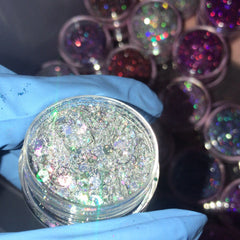 Close-up of Glitz Eye Shadow pot showing chunky silver glitter powder with high-shine particles in round black compact