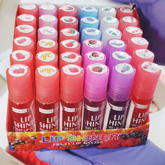 Lip gloss bundle pack with red, pink, and purple tubes, fruit labels, Beauty Treats brand visible